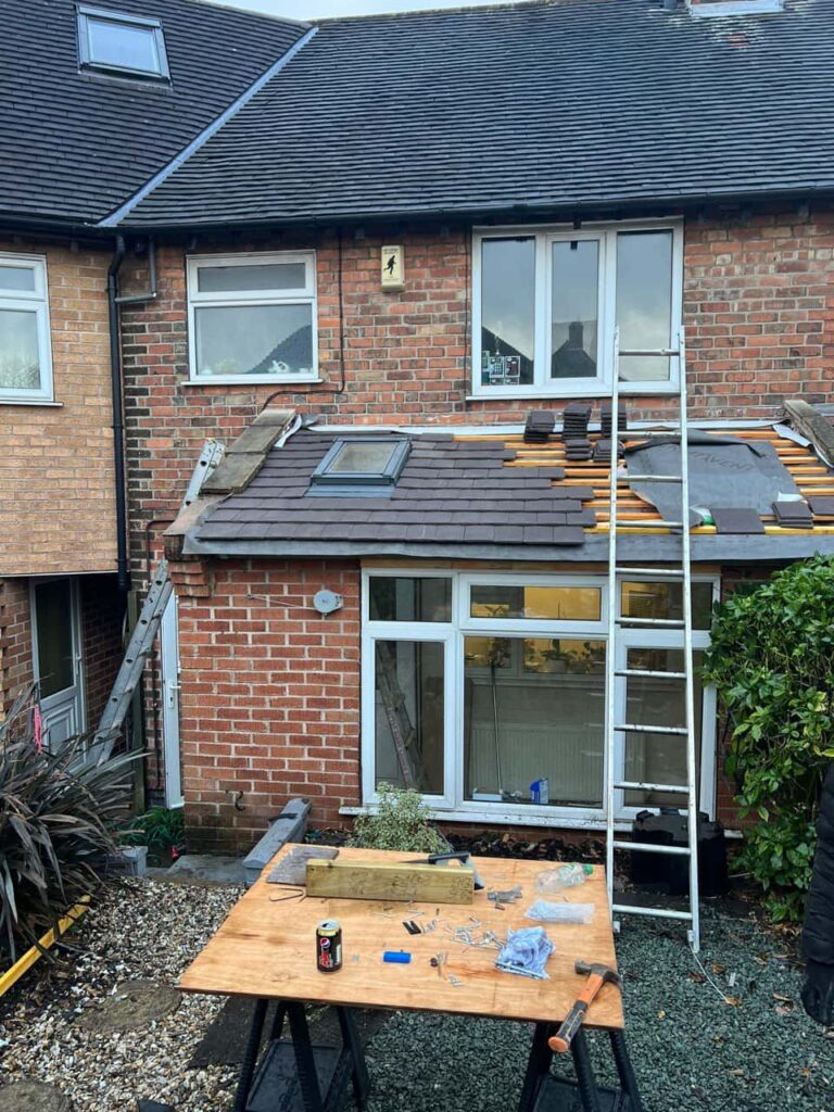 This is a photo of a roof extension that is having new roof tiles installed. This is a photo taken from the roof ridge looking down a tiled pitched roof on to a flat roof. Works carried out by Waterlooville Roofing Repairs